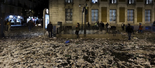 A woman takes a snapshot after a demonstration against layoffs of street cleaners and garbage collectors in Madrid, Spain, Monday, Nov. 4, 2013. Trash collectors in Madrid have started bonfires and set off firecrackers during a noisy protest in one of the Spanish capital’s main squares as they prepare to start an open-ended strike. Hundreds of street cleaners and garbage collectors who work in the city’s public parks converged on the Puerta del Sol plaza late Monday. (AP Photo/Daniel Ochoa de Olza)
