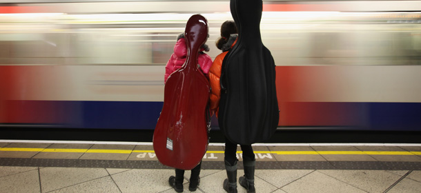 LONDON, ENGLAND - FEBRUARY 28: Two girls carrying Cellos wait for a train on London Underground's Westminster Station on February 28, 2012 in London, England. London's Underground system is the oldest of it's kind in the World, and carries approximately a quarter of a million people around it's network every day. (Photo by Dan Kitwood/Getty Images)