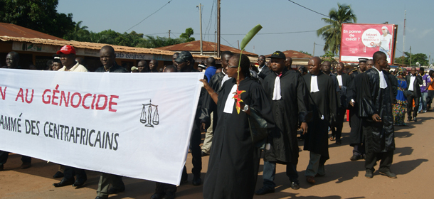Magistrates holding a banner reading "No To The Scheduled Genocide of Centrafricans" lead a demonstration to protest against the November 16 murder of the director of the Central African Judiciary services Modeste Martineau Bria on November 22, 2013 near the crime site in Sica, near Bangui. The United States is calling for deeper international involvement to halt violence in Central African Republic, amid growing alarm that the impoverished nation is on the brink of a possible genocide. The unrest has displaced almost 400,000 of the country's estimated 4.6 million people, left 2.3 million in need of assistance and some 1.1 million scrambling to find food, according to the latest UN figures. AFP PHOTO / PACOME PABANDJI (Photo credit should read PACOME PABANDJI/AFP/Getty Images)