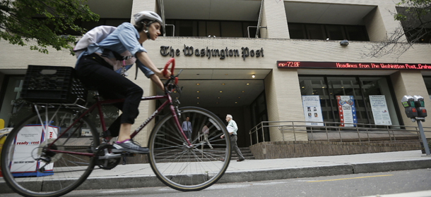 A bicyclist rides past the Washington Post building on Tuesday, Aug. 6, 2013, in Washington. Amazon.com founder Jeff Bezos bought the Washington Post for $250 million. (AP Photo/Pablo Martinez Monsivais)