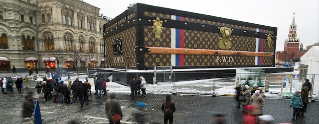 Tourists and visitors pass by a two-story Louis Vuitton suitcase erected at the Red Square in Moscow, Russia, Wednesday, Nov. 27, 2013. Politicians didn’t like it, the public didn’t like it, so the gigantic Louis Vuitton suitcase is being booted out of Red Square. The GUM department store on Red Square, which is responsible for 30-feet (nine meters) high and 100-feet (30-meters) long construction, promised in a statement released Wednesday that it would be dismantled. The GUM is at left and the Kremlin at right. (AP Photo/Pavel Golovkin)