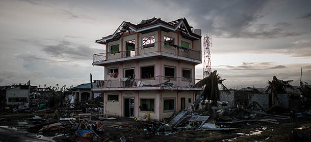 A the sun sets over a house damaged by Typhoon Haiyan outside the airport in Tacloban, on the eastern island of Leyte on November 12, 2013 after Super Typhoon Haiyan swept over the Philippines. The typhoon that destroyed entire towns across the Philippines is believed to have killed more than 10,000 people, which would make it the country&#8217;s deadliest recorded natural disaster. TOPSHOTS AFP PHOTO/Philippe Lopez (Photo credit should read PHILIPPE LOPEZ/AFP/Getty Images)
