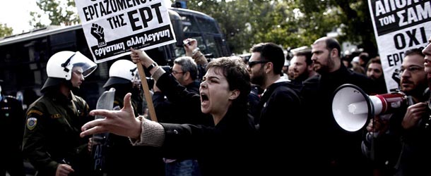 A demonstrator shouts at riot police on November 7, 2013 outside the headquarters of former public broadcaster ERT in Athens. Greek riot police burst into the headquarters of former public broadcaster ERT early on November 7 and forcibly removed employees who had been occupying the site since its shock shutdown five months ago. AFP / ANGELOS TZORTZINIS (Photo credit should read ANGELOS TZORTZINIS/AFP/Getty Images)
