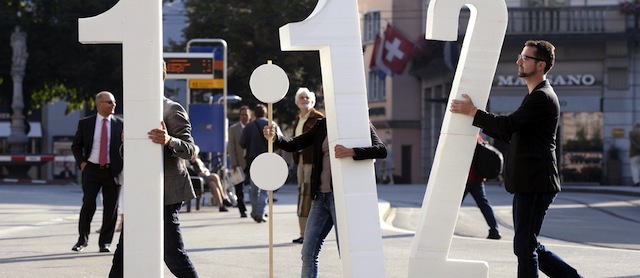 FILE - In this Aug. 30, 2013 file picture members of the Unia workers union demonstrate in Zurich, Switzerland to support a referendum. Voters in prosperous Switzerland are delivering their verdict on a proposal to limit the pay of companies' highest-paid managers to at most 12 times that of their lowest-paid workers. Sunday's Nov. 24, 2013 referendum comes after voters in March voiced anger at perceived corporate greed by voting to boost shareholders' say on executive pay and ban one-off bonuses known as "golden hellos" and "goodbyes." The young socialist backers of the new "1:12 initiative" say that imposing a legal limit on salaries would ensure fairer pay. (AP Photo/Keystone,Walter Bieri,File)