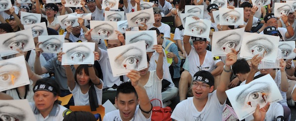 Protesters hold placards during an anti-military rally in front of Taiwan&#8217;s presidential office in Taipei on August 3, 2013. Tens of thousands of Taiwanese took to the streets on August 3 in protest over the death of a young conscript who died from alleged abuse. AFP PHOTO / Mandy CHENG (Photo credit should read Mandy Cheng/AFP/Getty Images)
