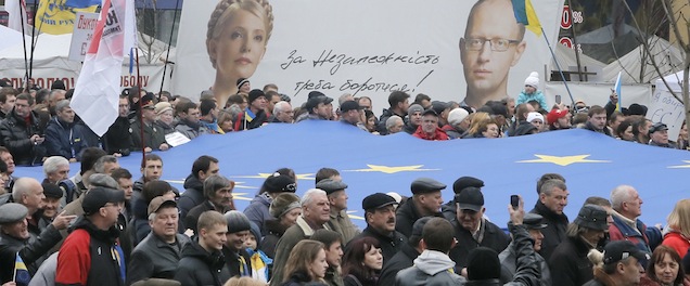 Tens of thousands of demonstrators carry EU flags as they march to demand the Ukrainian government reverse course and sign a landmark agreement with the European Union in defiance of Russia, as they pass by a poster of former Ukrainian Prime Minister Yulia Tymoshenko, left, and opposition leader Arseniy Yatsenyuk, in Kiev, Ukraine, Sunday, Nov. 24, 2013. The words on the poster reads, 'We must fight for independence'. The protest was the biggest Ukraine has seen since the peaceful 2004 Orange Revolution, which overturned a fraudulent presidential election result and brought a Western-leaning government to power. (AP Photo/Efrem Lukatsky)
