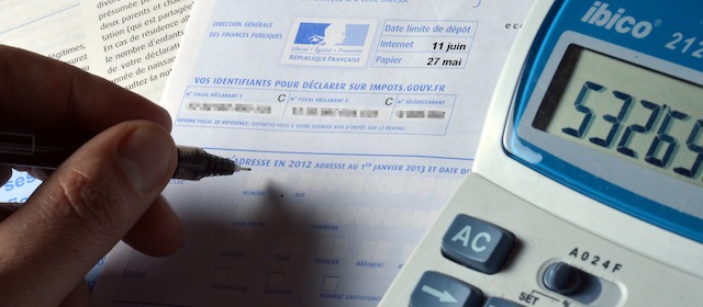 A person fills out a pre-filled tax declaration for the 2012 income tax on March 31, 2013 in Paris. AFP PHOTO / MIGUEL MEDINA