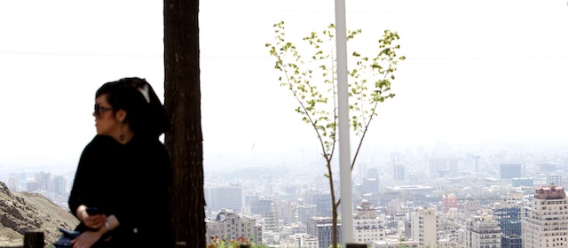 An Iranian woman sits on a fence overlooking a view of Tehran during their Noruz vacation from the foot of Tochal mountain in northern Tehran on April 1, 2013. Noruz, the new year according to the Persian solar calendar is a Zoroastrian tradition, still celebrated by Iranians even after Islam. AFP PHOTO/BEHROUZ MEHRI (Photo credit should read BEHROUZ MEHRI/AFP/Getty Images)