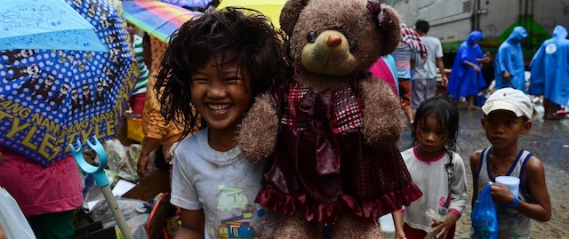 TACLOBAN, LEYTE, PHILIPPINES - DECEMBER 25: A girl holds up a teddy bear she found among piles of debris discarded by a grocery store on Christmas day on December 25, 2013 in Tacloban, Leyte, Philippines. Haiyan has been described as one of the most powerful typhoons ever to hit land, leaving thousands dead and hundreds of thousands homeless. Countries all over the world have pledged relief aid to help support those affected by the typhoon. With Christianity being the predominant religion in Philippines, the people of Tacloban will try to find a way to celebrate Christmas despite the incredibly difficult circumstances. (Photo by Dondi Tawatao/Getty Images)