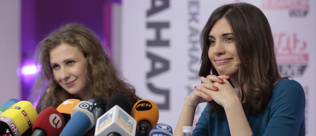 Russian punk band Pussy Riot members Nadezhda Tolokonnikova, right, and Maria Alekhina smile during their news conference in Moscow, Russia, on Friday, Dec. 27, 2013. Tolokonnikova and Alekhina who spent nearly two years in prison for their protest in Moscow's main cathedral said Friday they still want to topple Russian President Vladimir Putin. (AP Photo/Ivan Sekretarev)