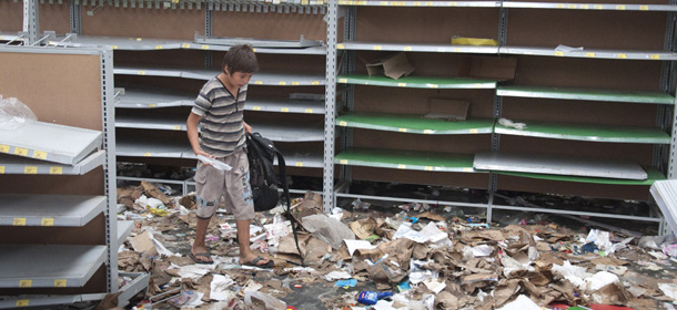A child walks through debris in a looted supermarket in San Miguel de Tucuman, Argentina, Tuesday, Dec. 10, 2013, Outbreaks of looting have spread across Argentina as mobs take advantage of strikes by police demanding pay raises to match inflation. The central government has dispatched federal police to trouble spots and appealed for an end to what some officials are calling treason. (AP Photo/Bruno Cerimele)