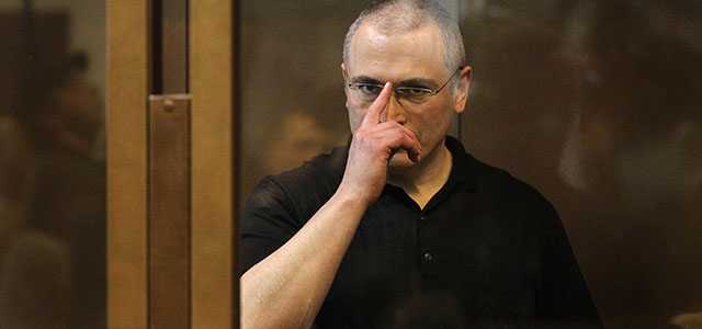 Yukos oil company chief executive officer Mikhail Khodorkovsky stands behind a glass wall at a courtroom in Moscow on May 24, 2011. A Moscow appeals court reduced the jail term of former oil tycoon Khodorkovsky and his former business partner Platon Lebedev by one year, meaning the fierce Kremlin critic may now be released from prison in 2016. AFP PHOTO/ ALEXEY SAZONOV (Photo credit should read Alexey SAZONOV/AFP/Getty Images)