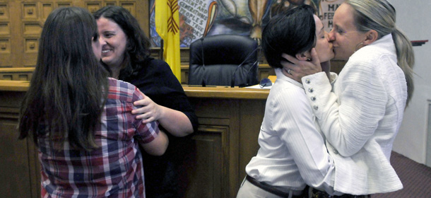 From left, Heidi Macdonald and her spouse Monica Ewing, from Santa Fe, and Krista Turner and her spouse Lisa Hunsicker, from Albuquerque, embrace after they were married along with nine other same-sex couples in the Santa Fe County Commission Chambers, Friday Aug. 23, 2013 in Santa Fe, N.M. The county clerk in the New Mexico state capital and the heart of this state's gay rights movement began issuing marriage licenses to gay and lesbian couples Friday, a court-ordered move that came just two days after a county clerk on the other end of the state decided on his own to recognize same-sex marriage. (AP Photo/The Albuquerque Journal, ) THE SANTA FE NEW MEXICAN OUT; MANDATORY CREDIT: EDDIE MOORE/THE ALBUQUERQUE JOURNAL (Eddie Moore/Associated Press/Albuquerque Journal)
