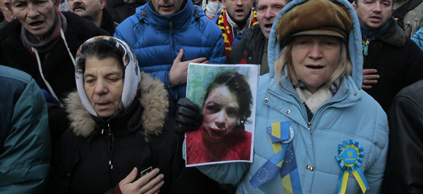 Activists hold the photo of journalist and activist Tetyana Chernovil as they rally outside the Ukrainian Interior Ministry in Kiev, Ukraine, Wednesday, Dec. 25, 2013. Tensions escalated further on Wednesday when a journalist and opposition activist, Tetyana Chernovil, was brutally beaten outside Kiev, hours after publishing a story on the lavish suburban residence that she said belongs to the country's embattled interior minister, a staunch Yanukovych ally. (AP Photo/Sergei Chuzavkov)