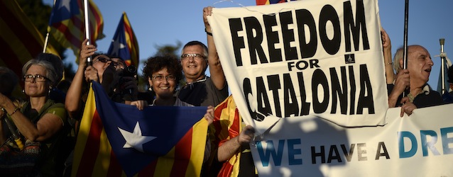 People wave "the Estelada" flags and hold up banners to demand the independence of Catalonia, outside the Economic Forum of the Western Mediterranean at the Palau de Pedralbes in Barcelona, Spain, Wednesday, Oct. 23, 2013. Catalonia claims a deep cultural difference based on its language, which is spoken side-by-side with Spanish in the wealthy region. (AP Photo/Manu Fernandez)