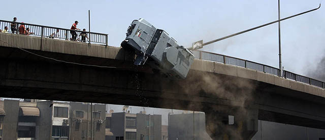 FOR USE AS DESIRED, YEAR END PHOTOS - FILE - A police vehicle is pushed off of the 6th of October bridge by protesters close to the largest sit-in by supporters of ousted Islamist President Mohammed Morsi in the eastern Nasr City district of Cairo, Egypt, Wednesday, Aug. 14, 2013. (AP Photo/Aly Hazzaa, El Shorouk Newspaper, File) EGYPT OUT