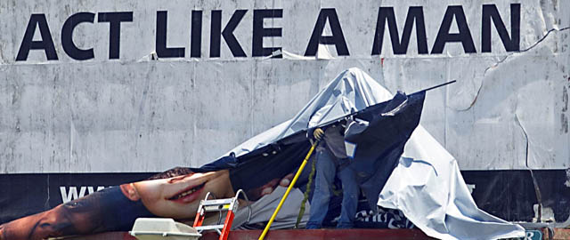Un uomo installa un grosso manifesto pubblicitario a Victoria, Texas, 20 maggio 2013 (AP Photo/Victoria Advocate, Frank Tilley)