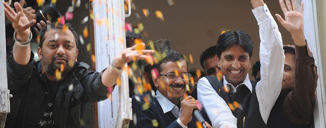 Arvind Kejriwal (C, holding microphone), leader of the Indian Aam Aadmi Party (Common Man's Party), waves to supporters from his office while surrounded by party members after winning the state assembly election against incumbent Sheila Dikshit in New Delhi on December 8, 2013. New Delhi's long-serving Chief Minister Sheila Dikshit lost her seat Sunday to the leader of a new anti-corruption party, state election results showed. Arvind Kejriwal, leader of the Aam Aadmi Party (Common People's Party), took an unassailable lead, winning 37,062 votes against 16,061 for Dikshit, according to the electoral commission. AFP PHOTO/SAJJAD HUSSAIN (Photo credit should read SAJJAD HUSSAIN/AFP/Getty Images)