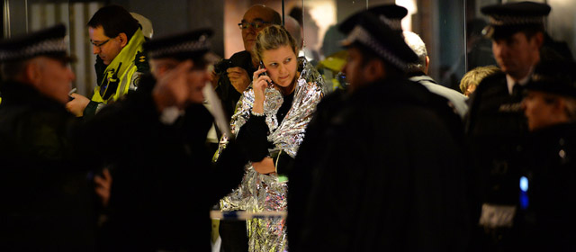 Police and emergency services personnel assist in operations behind a cordon following a ceiling collapse at a theatre in Central London on December 19, 2013. The ceiling of a top London theatre collapsed on the audience during a performance Thursday, causing what police said was an unknown number of casualties and leaving terrified theatregoers covered in blood and dust. AFP PHOTO/LEON NEAL (Photo credit should read LEON NEAL/AFP/Getty Images)