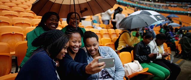 JOHANNESBURG, SOUTH AFRICA - DECEMBER 10: Some of the first people to arrive at the 95,000-seat FNB Stadium make photographs of themselves before the start of the official memorial service for former South African President Nelson Mandela December 10, 2013 in Johannesburg, South Africa. Over 60 heads of state have travelled to South Africa to attend a week of events commemorating the life of former South African President Nelson Mandela. Mr Mandela passed away on the evening of December 5, 2013 at his home in Houghton at the age of 95. Mandela became South Africa's first black president in 1994 after spending 27 years in jail for his activism against apartheid in a racially-divided South Africa. (Photo by Chip Somodevilla/Getty Images)