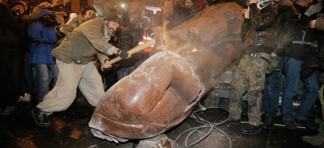 Ukrainian protesters smash a statue of Vladimir Lenin with a sledgehammer, in central Kiev, Ukraine, Sunday, Dec. 8, 2013. Anti-government protesters have toppled the statue of Bolshevik leader Vladimir Lenin in central Kiev amid huge protests gripping Ukraine. A group of protesters dragged down and decapitated the landmark statue Sunday evening after hundreds of thousands of others took to the streets to denounce the government's move away from Europe and toward Moscow (AP Photo/Efrem Lukatsky)