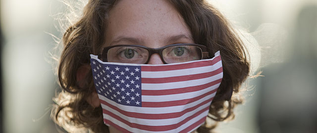 A demonstrator wearing a representation of the U.S. flag over her mouth and nose, participates in a protest outside the regional office of the presidency in Sao Paulo, Brazil, Thursday, July 18, 2013. Demonstrators gathered to show their discontent against the government's rejection of National Security Agency leaker Edward Snowden's asylum application, in early July. (AP Photo/Andre Penner)
