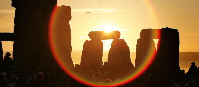 WILTSHIRE, UNITED KINGDOM - JUNE 21: People watch the midsummer sun as it rises over the megalithic monument of Stonehenge on June 21, 2005 on Salisbury Plain, England. Crowds gathered at the ancient stone circle to celebrate the Summer Solstice; the longest day of the year in the Northern Hemisphere. (Photo by Peter Macdiarmid/Getty Images)