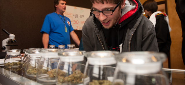 Tyler Williams of Blanchester, Ohio selects marijuana strains to purchase at the 3-D Denver Discrete Dispensary in Denver, Colorado. Legalization of recreational marijuana sales in the state went into effect at 8am this morning.