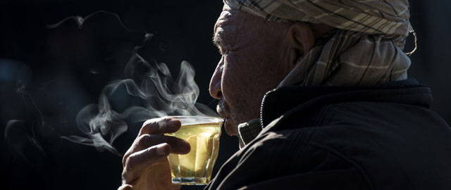 Un uomo beve un tè in un negozio di auto di seconda mano, 11 gennaio 2014 (JOHANNES EISELE/AFP/Getty Images)