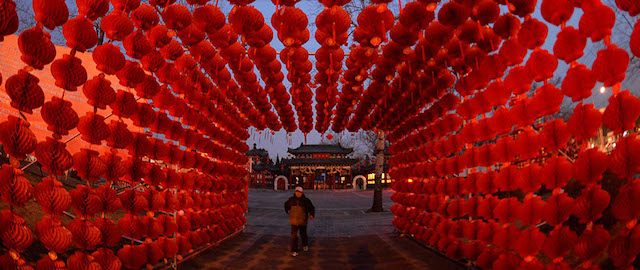 A man walks beneath a display of lanterns for the Lunar New Year as China prepares for the Year of the Horse in Beijing on January 28, 2014. China is preparing to welcome the Lunar New Year of the Horse which falls on January 31 and will see about 3.62 billion trips made by Chinese travelers during the 40-day Spring Festival travel period. AFP PHOTO/Mark RALSTON (Photo credit should read MARK RALSTON/AFP/Getty Images)