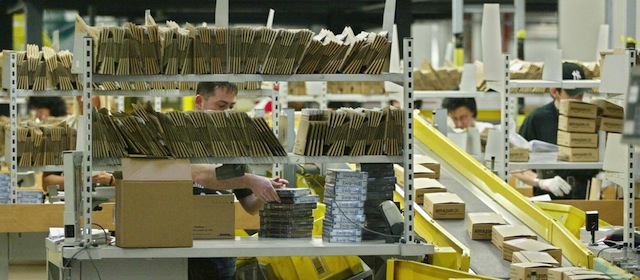 BAD HERSFELD, Germany: Employees of Amazon.de, the German branch of US online retailer Amazon.com, pack books into parcels ready to be sent to the clients, 04 December 2004 in Germany's Amazon distribution central in the western town of Bad Hersfeld. Amazon.de sells books, music, DVDs and videos among other things via internet. AFP PHOTO DDP/MARTIN OESER GERMANY OUT (Photo credit should read MARTIN OESER/AFP/Getty Images)