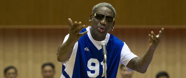 Dennis Rodman sings Happy Birthday to North Korean leader Kim Jong Un, seated above in the stands, before an exhibition basketball game at an indoor stadium in Pyongyang, North Korea on Wednesday, Jan. 8, 2014. (AP Photo/Kim Kwang Hyon)