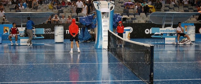 Richard Gasquet of France, right, and Tommy Robredo of Spain, left sit in a chair as rain stopped play during their third round match at the Australian Open tennis championship in Melbourne, Australia, Friday, Jan. 17, 2014.(AP Photo/Rick Rycroft)