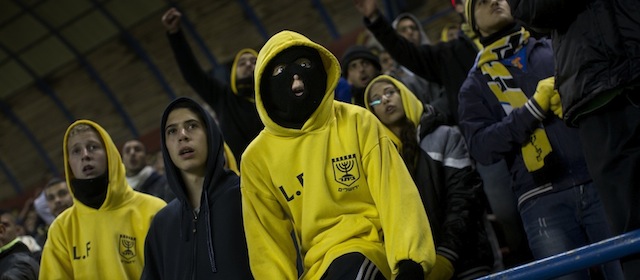 In this Tuesday, Jan. 29, 2013 photo Beitar Jerusalem F.C. soccer supporters watch a State Cup soccer match against Maccabi Umm al-Fahm F.C. at the Teddy Stadium in Jerusalem. Beitar has long tried to quell a tight-knit group that calls itself "La Familia" and whose behavior has had the team docked points and forced it to play before empty stadiums. The group is routinely abusive toward opposing players, taunting them with racist and anti-Arab chants. (AP Photo/Bernat Armangue) The offices of the Beitar Jerusalem soccer team were set on fire early Friday in an apparent arson attack, police said, a day after four of the club's fans were charged with anti-Muslim chanting at a recent game. Tensions have been bubbling ever since the team announced last month it would sign on two Muslim Chechen players — Zaur Sadayev and Gabriel Kadiev — in a break from the team's unofficial tradition of not signing Arabs or Muslims. (AP Photo/Bernat Armangue)