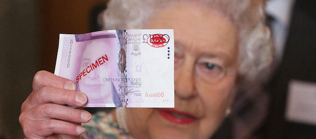 Britain's Queen Elizabeth II holds up a specimen of a 100 pound note demonstrating a new security strip, during a reception for the winners of the Queens Award for Enterprise 2013, at Buckingham Palace in London, Tuesday July 23, 2013. (AP Photo/Philip Toscano, Pool)