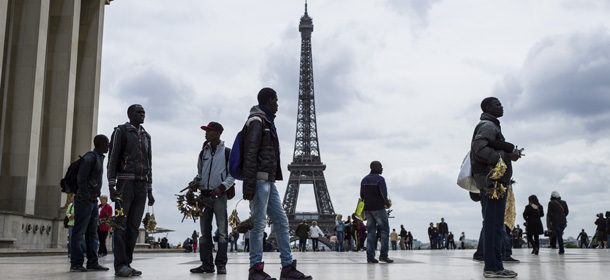 Street hawkers wait in front of the Eilffel Tower on Trocadero Square on May 14, 2013 in Paris. Paris's image, already tarnished by alarm over recent tourist muggings, has taken a further bashing after violence during a trophy parade to mark Paris Saint-Germain's first French League win in 19 years. The shock violence occurred late Monday after up to 15,000 PSG fans, who had thronged the esplanade at Trocadero by the iconic Eiffel Tower to mark the victory, turned unruly and attacked tourists and others in the heart of the city. AFP PHOTO / FRED DUFOUR (Photo credit should read FRED DUFOUR/AFP/Getty Images)
