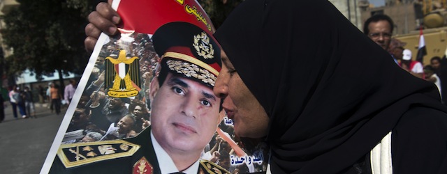 An Egyptian woman kisses a poster of General Abdel Fattah al-Sisi as she arrives into Tahrir Square to mark the 40th anniversary of the 1973 Arab-Israeli war on October 6, 2013 in the capital Cairo. Egypt braced for rival demonstrations called by supporters and opponents of deposed Islamist president Mohamed Morsi during the anniversary's festivities. AFP PHOTO / KHALED DESOUKI (Photo credit should read KHALED DESOUKI/AFP/Getty Images)