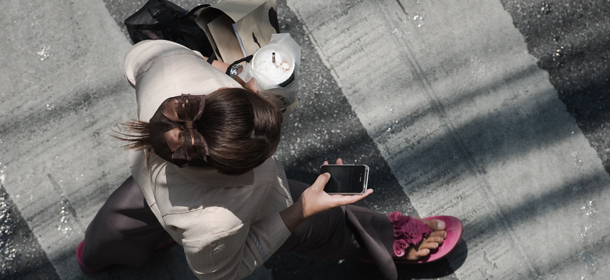 This picture taken on March 20, 2013 shows a woman looking at her smartphone while walking in a street in Bangkok. A recent Facebook-sponsored study showed smartphone owners are often connected all day. People can be found glued to their smartphones at airports, on trains, in restaurants and even while walking on the street, creating a disconnection from their immediate surroundings. Smartphone sales are expected to continue to surge in 2013 with some 918 million units to be bought worldwide. AFP PHOTO/ Nicolas ASFOURI (Photo credit should read NICOLAS ASFOURI/AFP/Getty Images)