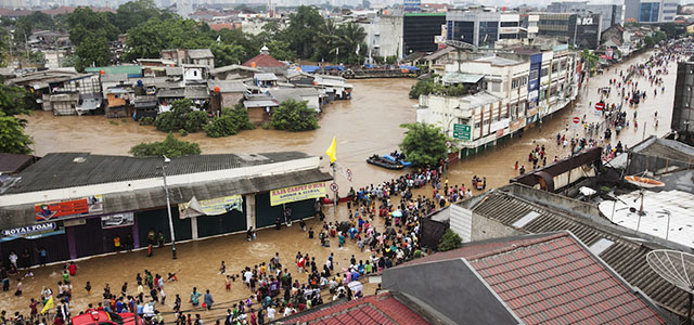 JAKARTA, INDONESIA - JANUARY 18: People walk through the flooded streets at Kampung Pulo on January 18, 2014 in Jakarta, Indonesia. Over 40,000 people have been displaced after heavy rains have severly fooding northern Indonesia and has left at least 13 dead. (Photo by Oscar Siagian/Getty Images)