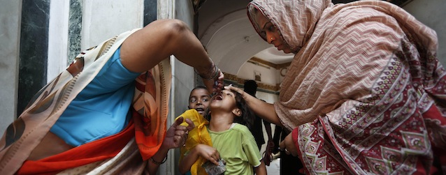 Indian health workers administer polio vaccine to a young girl as she visits a mosque in New Delhi, India, Tuesday, April 9, 2013. India marked a major success in its battle against polio last year by being removed from the World Health Organization's list of countries plagued by the crippling disease. The country will have to pass without registering any new cases till February next year to be declared polio-free. (AP Photo/Saurabh Das)