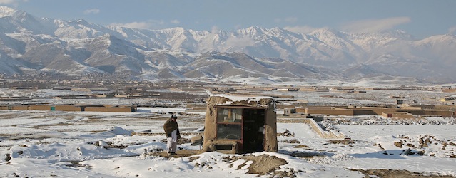 An Afghan shopkeeper stands next to his shop on the outskirts of capital Kabul, Afghanistan, Thursday, Jan. 9, 2014. Afghanistan experiences cold winters, and the slow pace of development and soaring cost of living in the country have made life more difficult for the locals. (AP Photo/Massoud Hossaini)