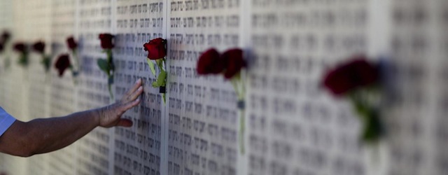 Mideast wars veteran touches the wall of names at the Armored Corps memorial for fallen soldiers after a ceremony marking the annual Memorial Day for soldiers and civilians killed in more than a century of conflict between Jews and Arabs, in Latrun near Jerusalem, Israel, Monday, April, 15, 2013. Israel says 23,085 security personnel have been killed since 1860, when Jews began moving back to the area. (AP Photo/Ariel Schalit)