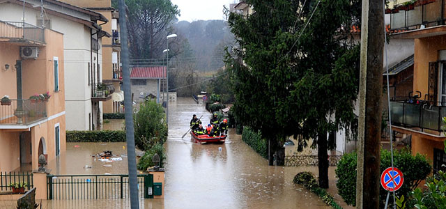 Firefighters rescue people on a small boat in a flooded street in "Prima Porta", in the outskirts of Rome, after torrential rains hit the region overnight on January 31, 2014. AFP PHOTO / TIZIANA FABI (Photo credit should read TIZIANA FABI/AFP/Getty Images)