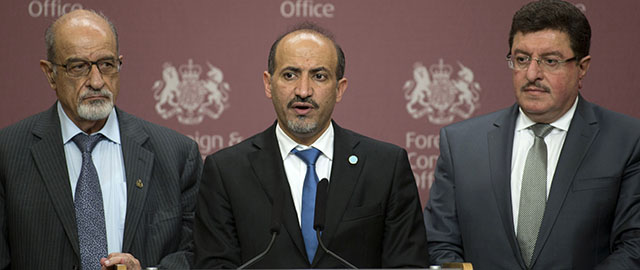 FILE - In this Oct. 22, 2013, file photo, Syrian National Coalition chief Ahmed Jarba, center, Heitham Al-Maleh, left, and Salem Al-Muslit speak to the media at the British Foreign Office in London. Two weeks ahead of an international peace conference on Syria, the country’s main Western-backed opposition group stands on the brink of collapse, dragged down by outside pressures, infighting and deep disagreements over the basic question of whether to talk to President Bashar Assad. (AP Photo/Alastair Grant, File)
