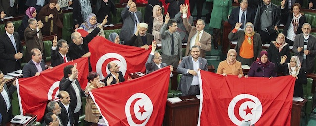 In this photo dated Sunday, Jan. 26, 2014, members of the Tunisian National Constituent Assembly celebrate the adoption of the new constitution in Tunis, Tunisia. After decades of dictatorship and two years of arguments and compromises, Tunisians on Sunday finally have a new constitution laying the foundations for a new democracy. The document is groundbreaking as one of the most progressive constitutions in the Arab world — and for the fact that it got written at all. It passed late Sunday by 200 votes out of 216 in the Muslim Mediterranean country that inspired uprisings across the region after overthrowing a dictator in 2011. (AP Photo/Aimen Zine)