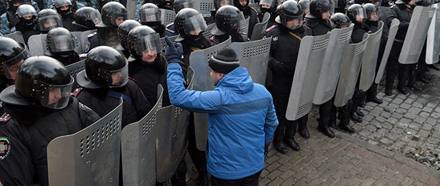 A protester speaks to armour-clad security forces blocking access to the Verkhovna Rada parliament in Kiev on January 21, 2014 during clashing break of the opposition and the police. Russia on Tuesday warned the situation in Ukraine was spiralling out of control after a second night of violent clashes between pro-EU protesters and security forces in the centre of Kiev.AFP PHOTO/ SERGEI SUPINSKY (Photo credit should read SERGEI SUPINSKY/AFP/Getty Images)