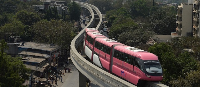In this photograph taken on January 29, 2014, the Mumbai Monorail train makes its way through the city's eastern suburbs during a run between Wadala and Chembur in Mumbai. Starting February 2, 2014, Mumbai will become the first city in India to use a monorail when the first phase - an 8.93 km long section - will be open to the public following inauguration on February 1. Construction of the 20 km long monorail project, which is running almost two years behind schedule, began in 2009. The four-coach monorail train with a capacity to carry over 560 passengers will run at an average speed set at 65 kilometres per hour (40 mph), with a top speed of 80 kilometres per hour (50 mph). AFP PHOTO/ INDRANIL MUKHERJEE (Photo credit should read INDRANIL MUKHERJEE/AFP/Getty Images)