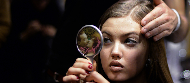 Models get ready backstage before Versace show as part of the presentations of the Women's fashion week Autumn/Winter 2014 collections in Milan on February 20, 2014. AFP PHOTO / Filippo MONTEFORTE (Photo credit should read FILIPPO MONTEFORTE/AFP/Getty Images)