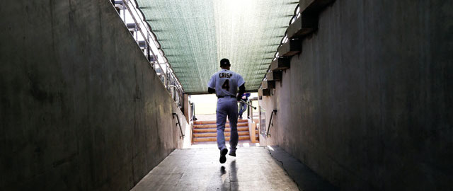 Oakland Athletics center fielder Coco Crisp heads to the field during the team's photo day before a spring training baseball practice Saturday, Feb. 22, 2014, in Phoenix. (AP Photo/Gregory Bull)