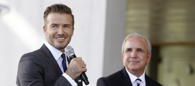 Former English soccer star David Beckham, left, speaks at a news conference where he announced he will exercise his option to purchase a Major League Soccer expansion team in Miami, Wednesday, Feb. 5, 2014, in Miami. At right is Miami-Dade County mayor Carlos Gimenez, (AP Photo/Lynne Sladky)